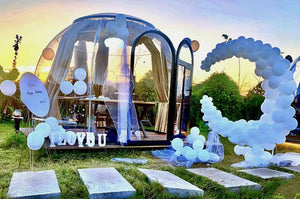 Earth Haven decorated transparent pod for a birthday party with balloons and 'I Love You' sign, creating a festive outdoor celebration atmosphere.